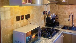 Uma cozinha moderna com micro-ondas, fogão e pia embutidos.