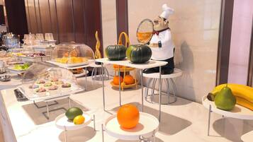 A buffet with various food items and a decorative chef figure.