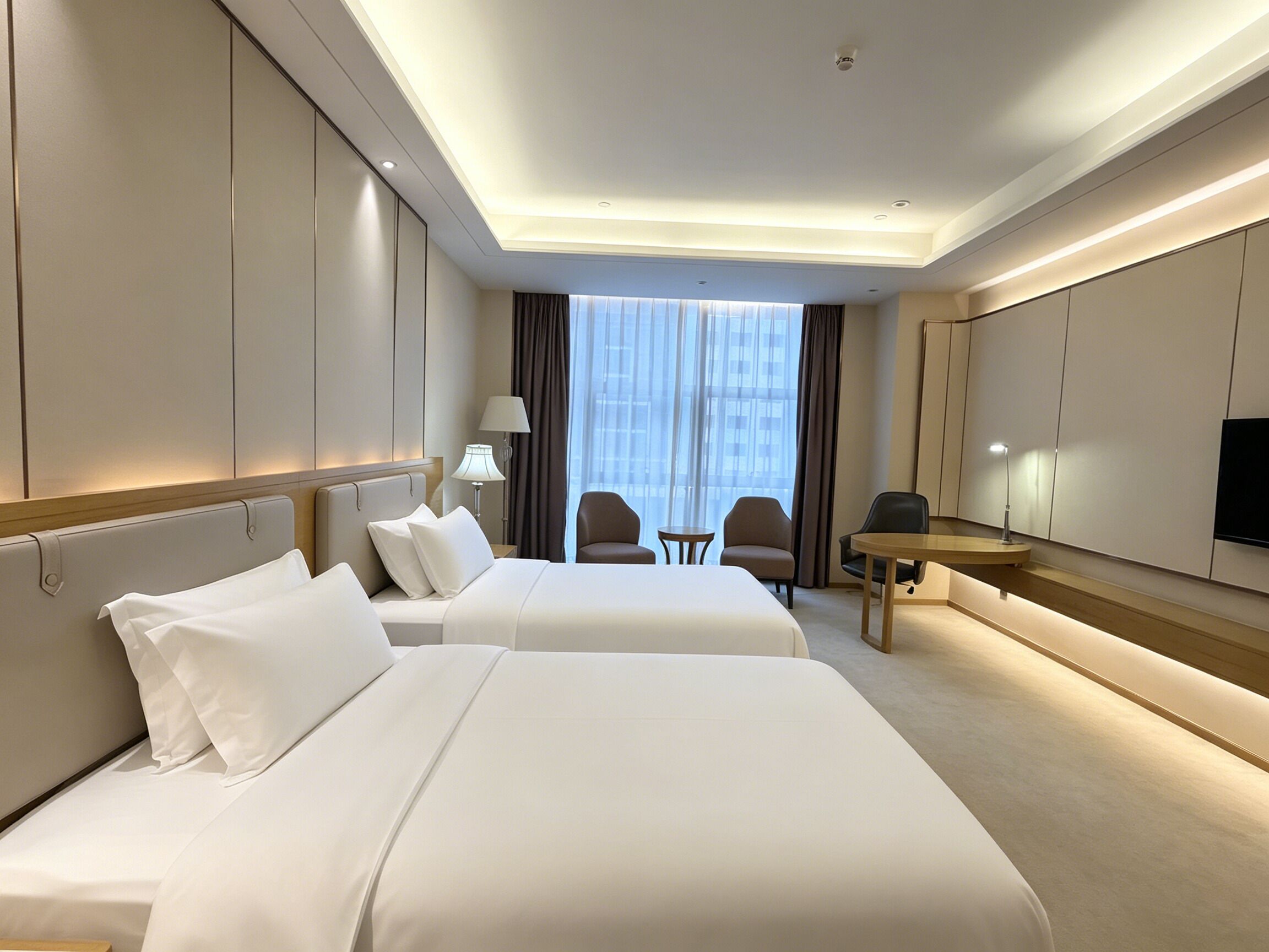 A hotel room with two beds, a desk, a chair, and a TV.