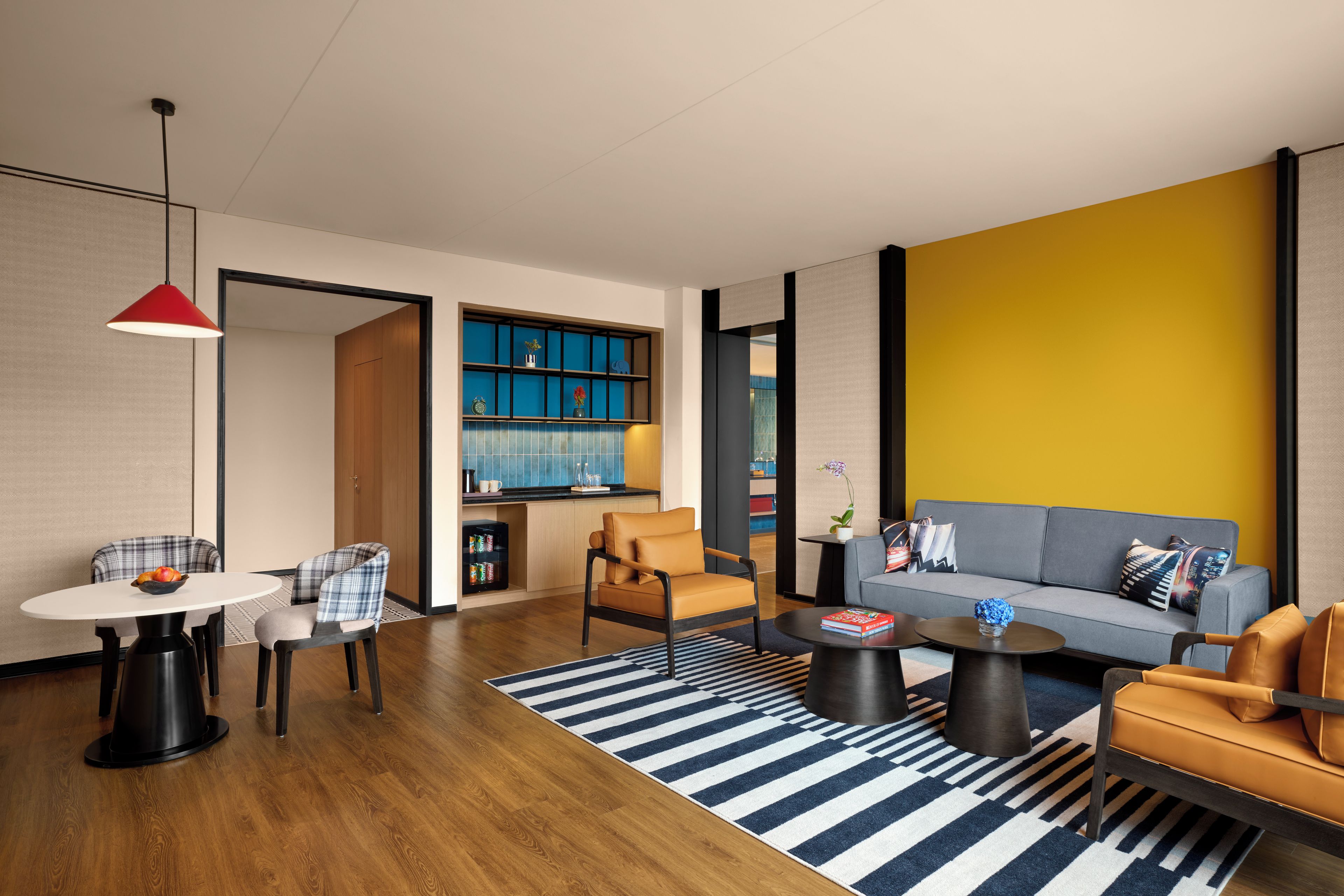 Una sala de estar moderna con un sofá, sillas, una mesa de centro y un comedor con una mesa y sillas.