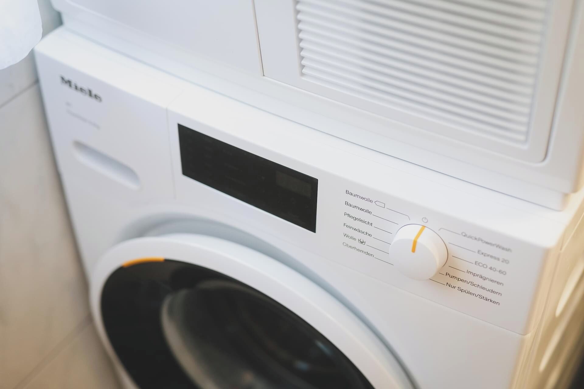 A front view of a white washing machine with a control panel featuring various settings.
