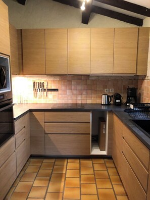 A modern kitchen with wooden cabinets, a tiled backsplash, and a built-in dishwasher. - Domaine de Fanny : Heart of Provence - 14 persons (Entrecasteaux)