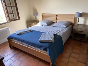 A bed with a blue blanket, two pillows, and a wooden headboard. There are two bedside tables with lamps. - Domaine de Fanny : Heart of Provence - 14 persons (Entrecasteaux)