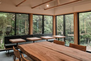 A modern dining area with a large wooden table, benches, and chairs.