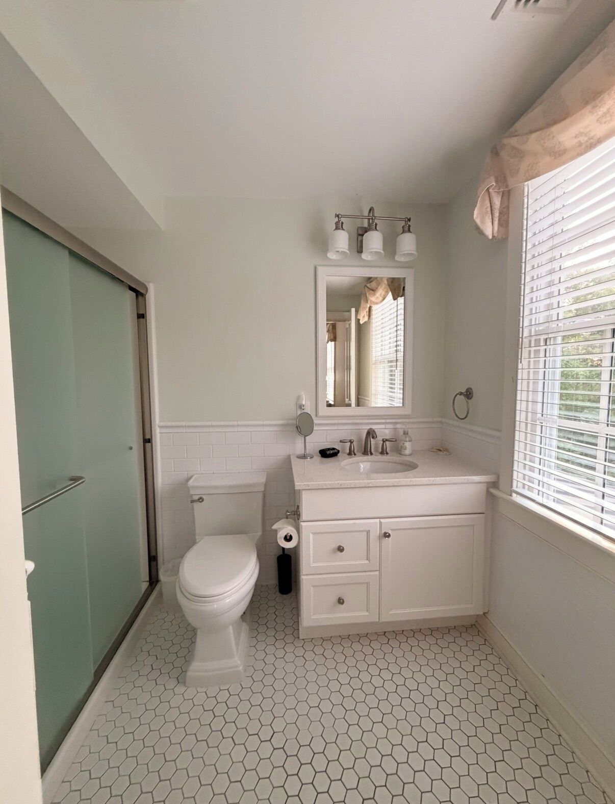 Une salle de bain comprenant des toilettes, un lavabo et un espace douche.