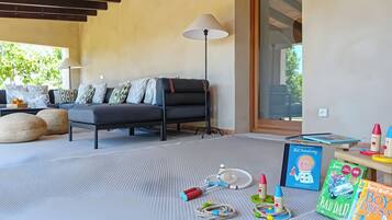 Een moderne woonkamer met een bank, een lamp en kinderspeelgoed.