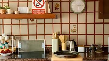 A kitchen with a stove, oven, and various kitchen items on the counter.