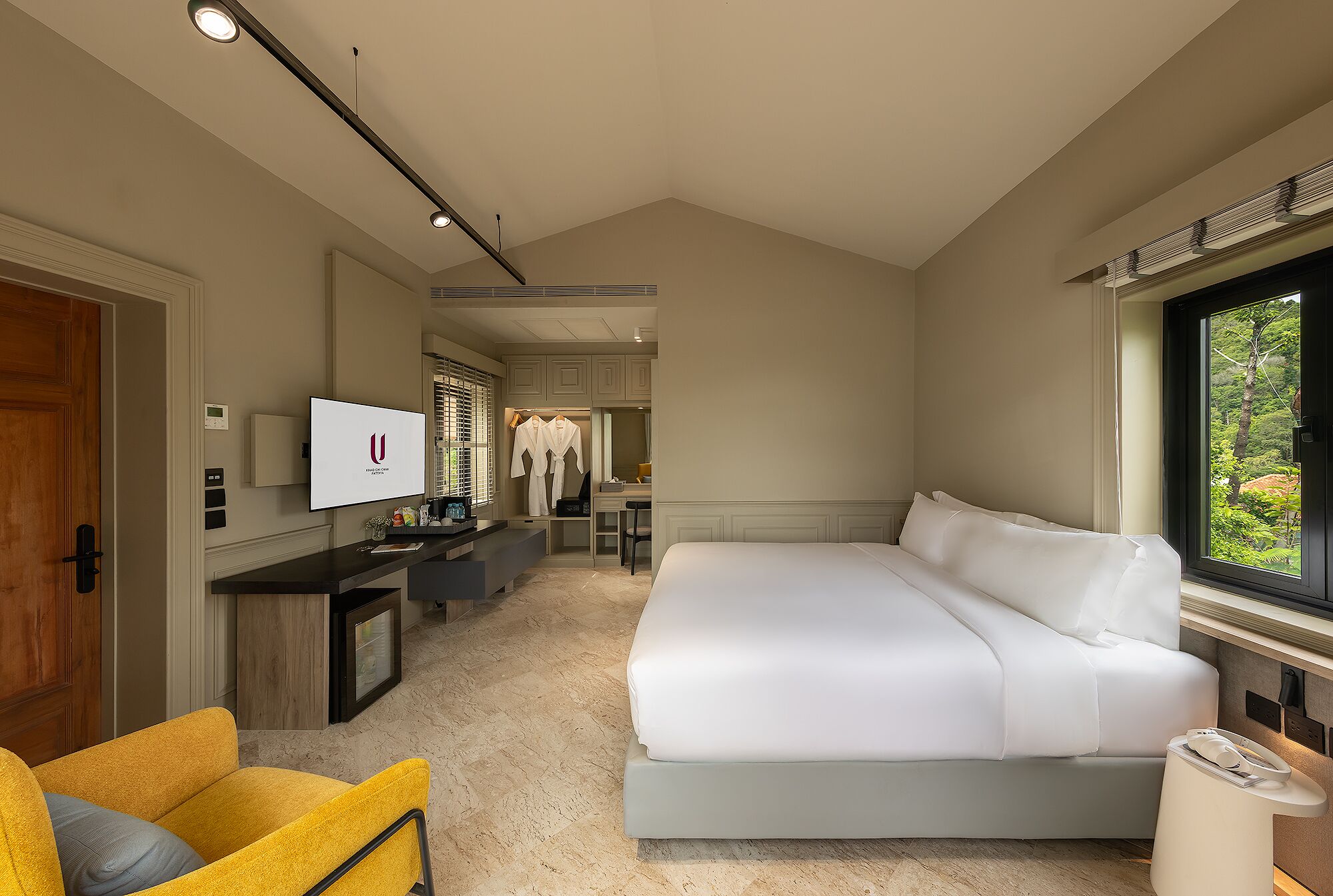 Quarto moderno com uma cama grande, uma escrivaninha e uma cadeira.
