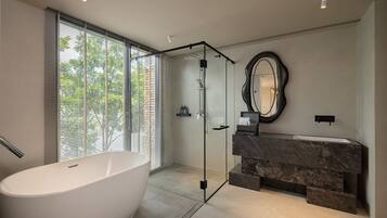 A modern bathroom with a freestanding bathtub, a glass-enclosed shower, and a marble vanity.