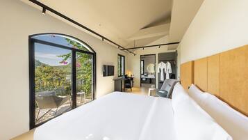 Un dormitorio moderno con una cama grande, un escritorio y vistas a un balcón.