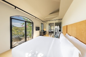 Une chambre moderne avec un grand lit, un bureau et une vue sur un balcon.