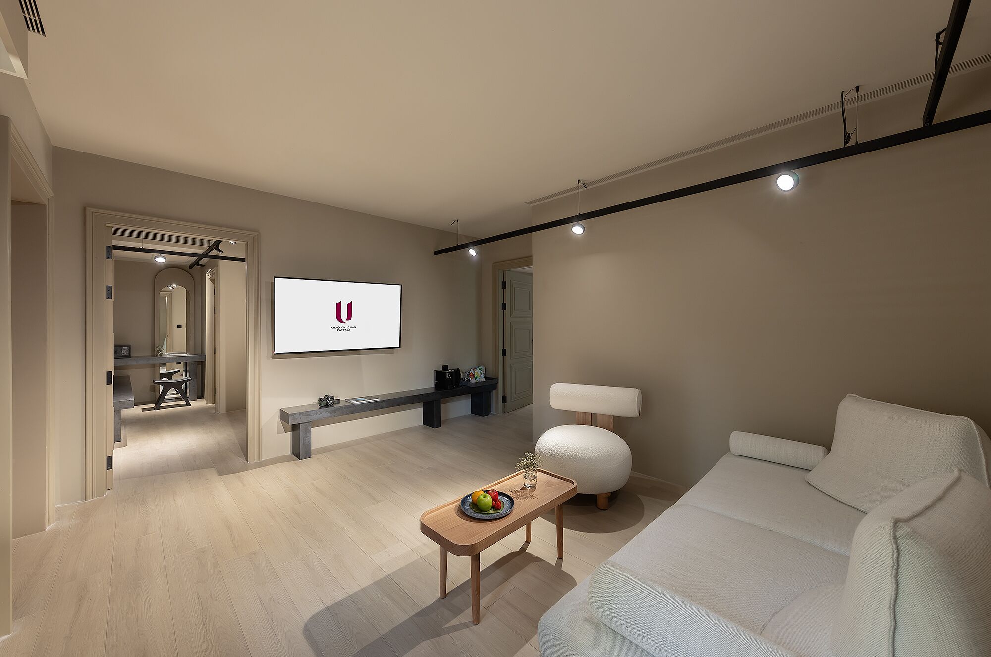 Una sala moderna con un televisor de pantalla plana, un sofá, una mesa de centro y una lámpara.