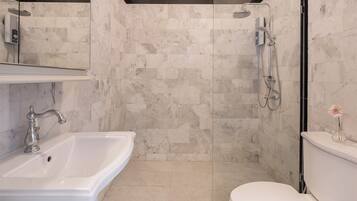 Un baño moderno con ducha, inodoro y lavamanos.