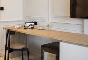 A modern kitchen with a wooden countertop, a tablet displaying a photo gallery, a vase with flowers, and a black chair.