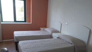 A room with two beds, a window, and a nightstand. - VIVA CAMPUS (Ferrazzano)