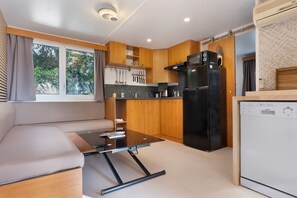 A compact kitchen with a built-in refrigerator, a coffee machine, and a microwave. - Bungalow “L’échappée” with Mountain View, Wi-Fi, and Air Conditioning (Saint-Alban-Auriolles)