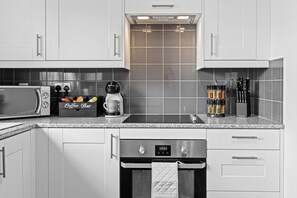 Eine moderne Küche mit eingebauter Mikrowelle, Kaffeemaschine und einer Kaffeoeinrichtung.