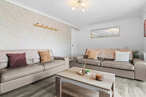 A modern living room with two sofas, a coffee table, and a decorative shelf. - Prime location Pad/Free Parking/PS4/Wifi/Tourists (Salford)