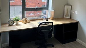 A compact office space with a desk, chair, and a window overlooking a brick building. - Electric Press  (Sheffield)