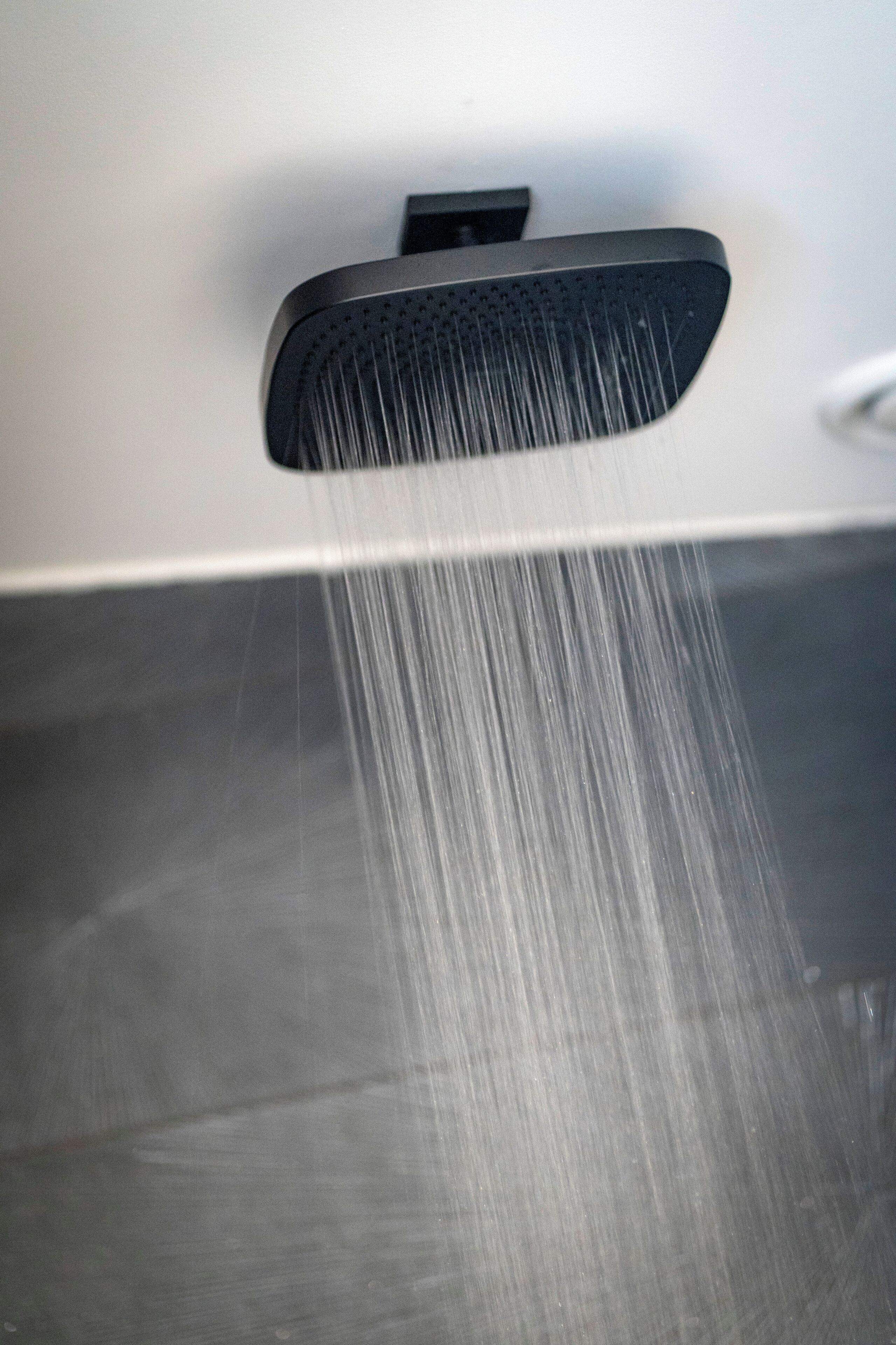 Un cabezal de ducha con agua corriendo.