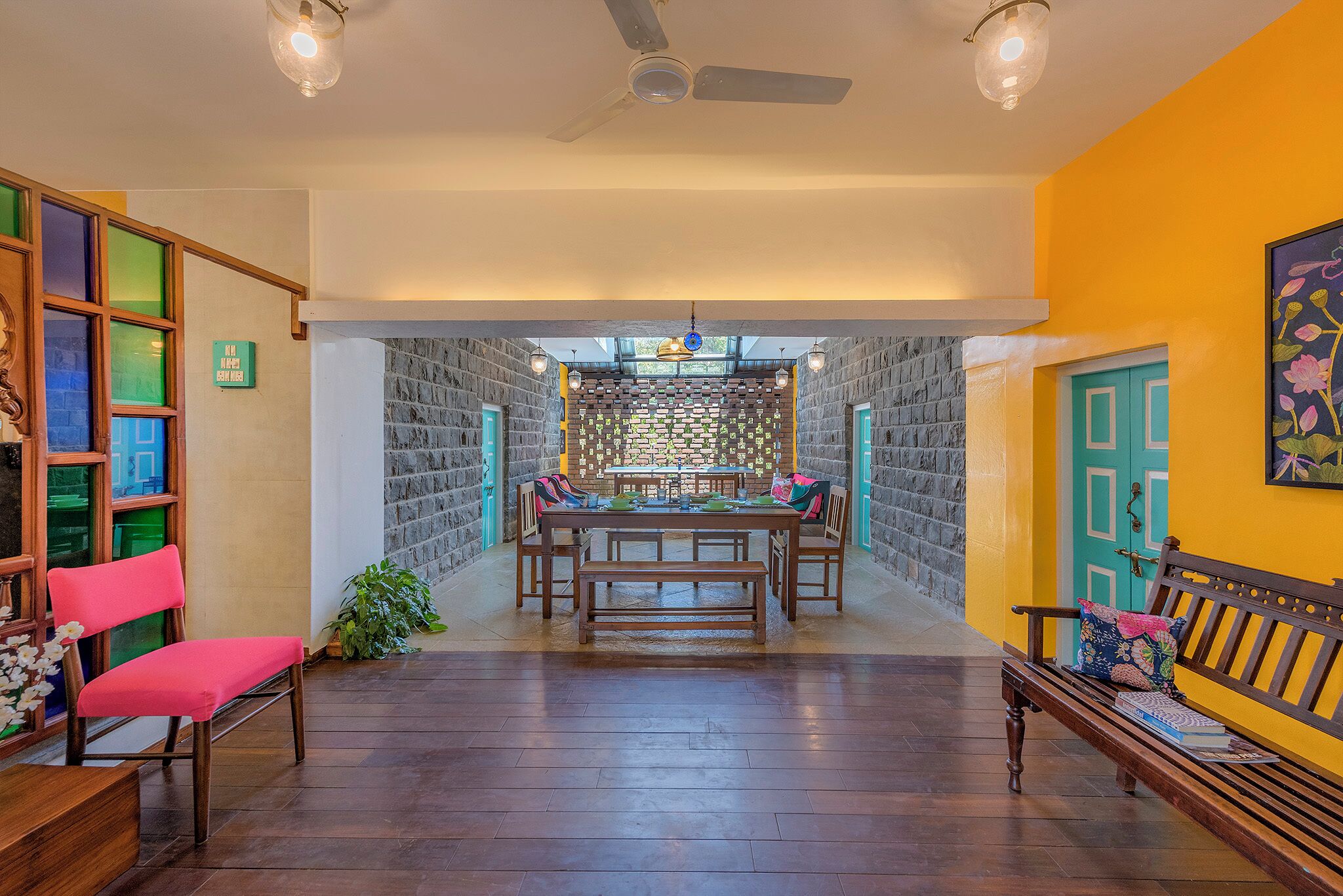 A dining area with a brick wall, wooden table, and benches.