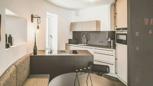 A modern kitchen with a dining area, a sofa, and a table. - Water tower with Alpine panorama in Chiemgau (Trostberg)
