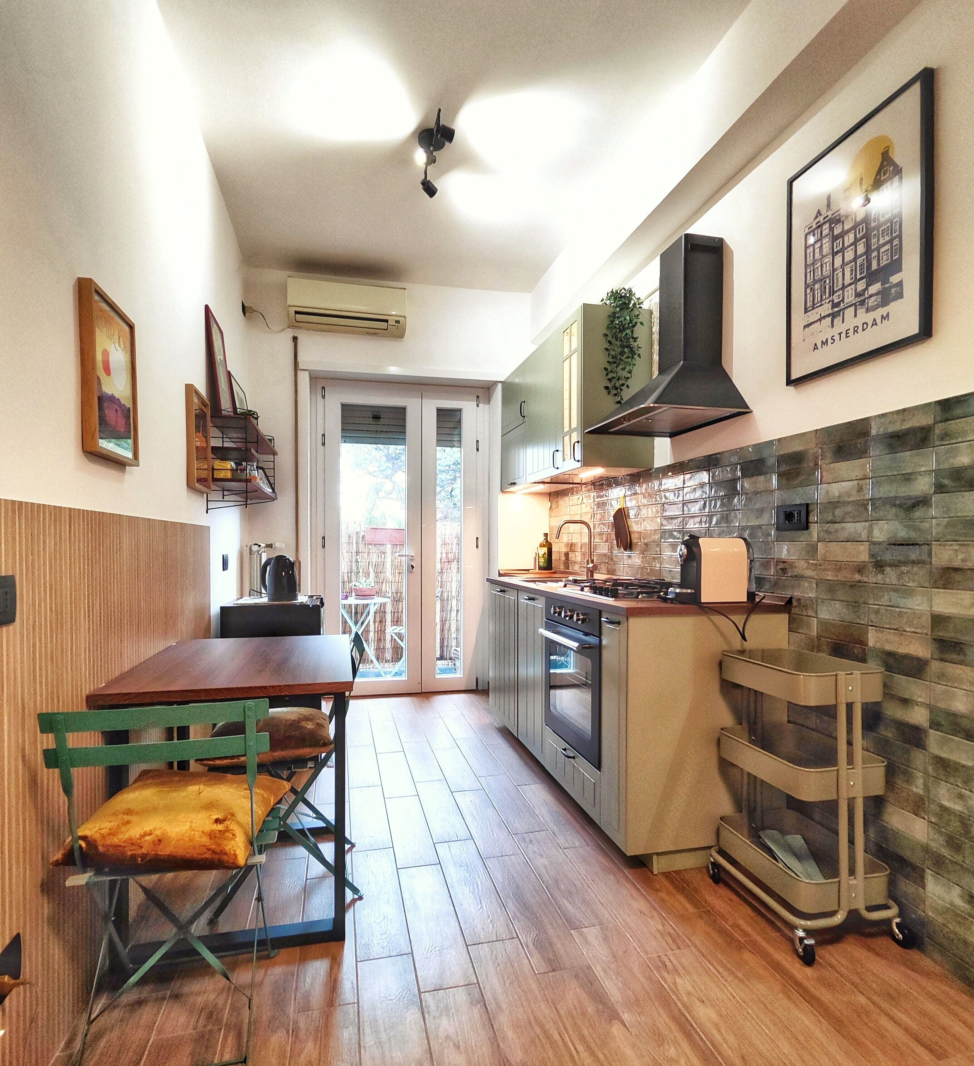 Una cocina moderna con comedor, estufa, horno y una planta colgante.