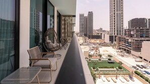 Ein Balkon mit Blick auf eine Stadtlandschaft, darunter Hochhäuser und eine Baustelle.