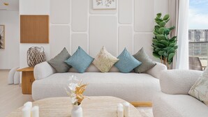Ein modernes Wohnzimmer mit einer Couch, Zierkissen, einem Beistelltisch und einer Pflanze.