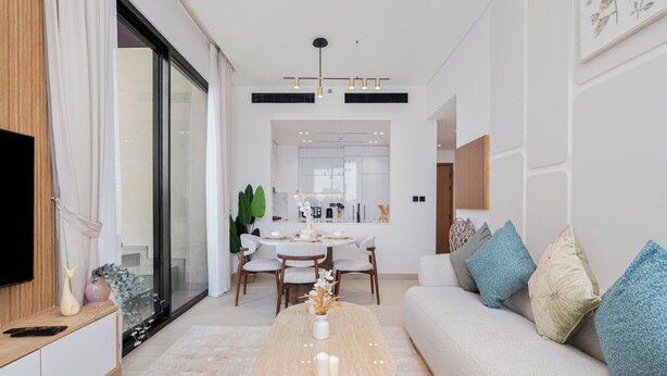 Ein modernes Wohnzimmer mit einer Couch, einem Couchtisch und einem Essbereich mit Stühlen und einem Tisch.