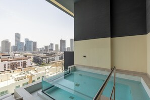 A rooftop swimming pool with a city view, surrounded by buildings. - Gala Guests - Binghatti Onyx Suites (Jumeirah Village Circle)