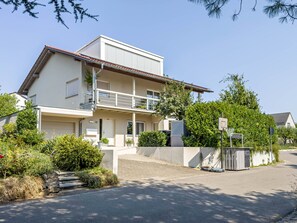 Ein zweistöckiges Wohnhaus mit Balkon, Garage und gepflegtem Garten.