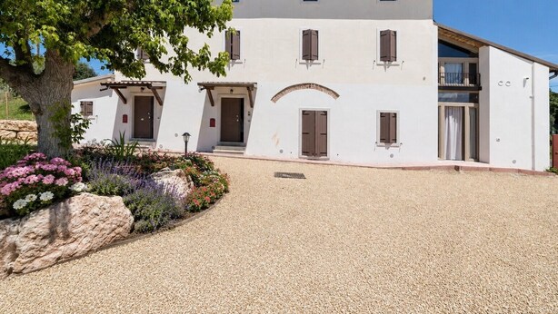 A two-story building with a symmetrical facade, multiple windows, and a central entrance. - Casale dei Sogni Entire Private Villa with Terrace, Wi-Fi, and Air Conditioning (Cavaion Veronese)