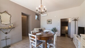A dining area with a round table, white chairs, a chandelier, and a mirror on the wall. - Casale dei Sogni Entire Private Villa with Terrace, Wi-Fi, and Air Conditioning (Cavaion Veronese)