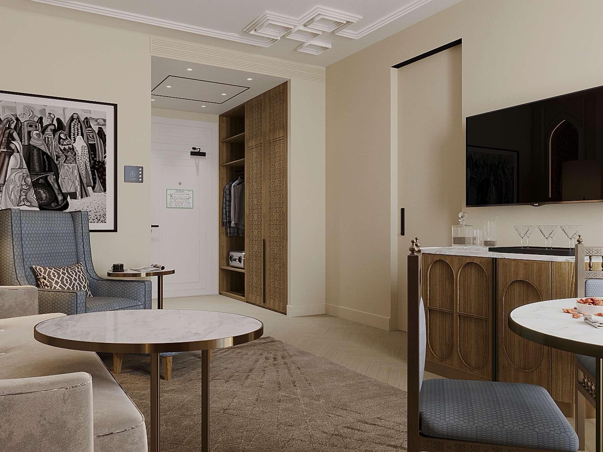 A modern living room with a sofa, a round coffee table, and a TV mounted on the wall.