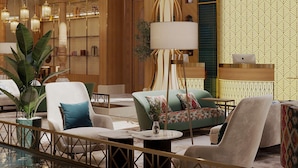 Un vestíbulo moderno con áreas de estar, un mostrador de recepción e iluminación decorativa.