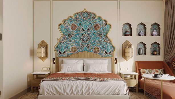 Habitación de hotel con una cama grande, un cabecero decorativo, dos mesitas de noche, una zona de estar y adornos en la pared.