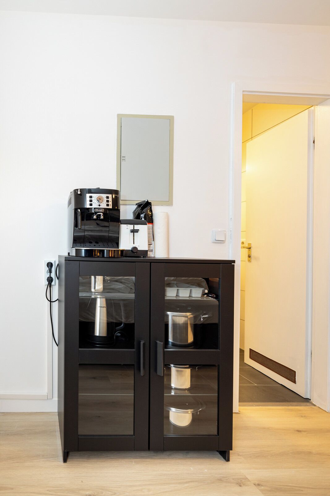 A kitchenette with a coffee machine, a microwave, and a refrigerator.