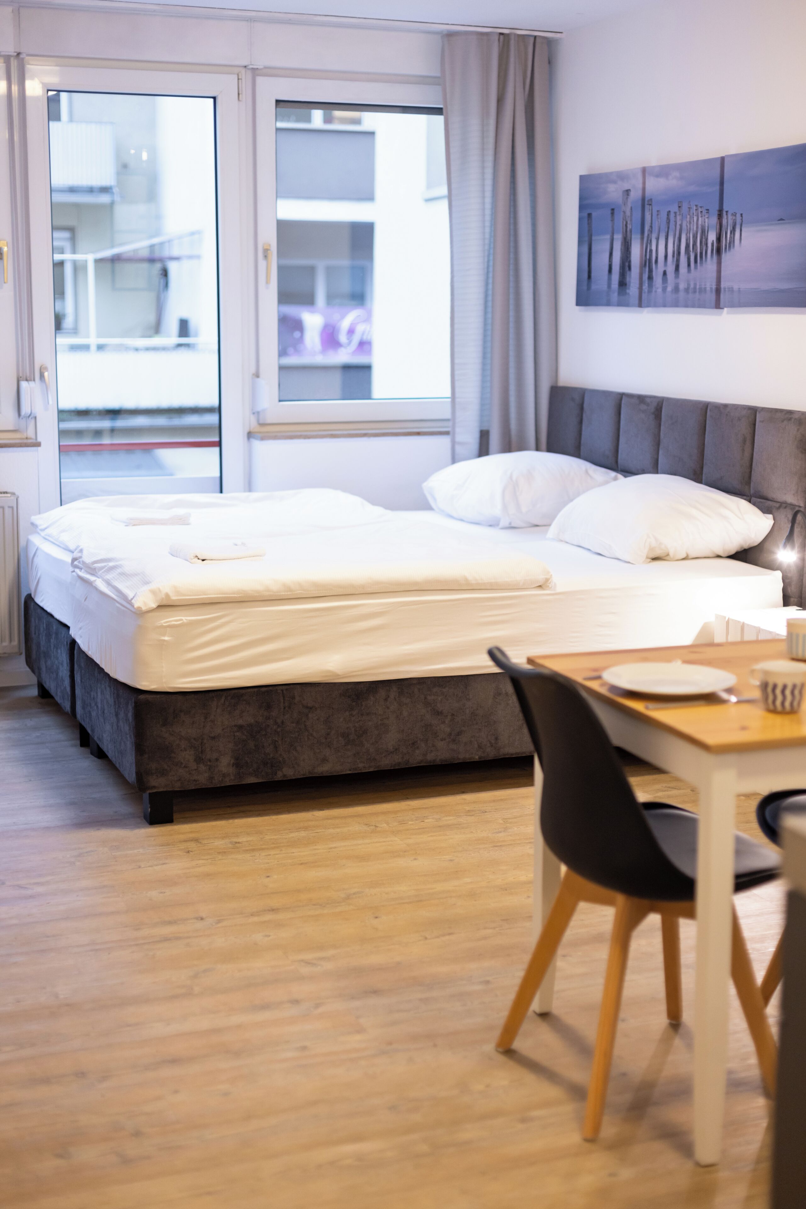 A hotel room with a bed, a desk, and a chair.