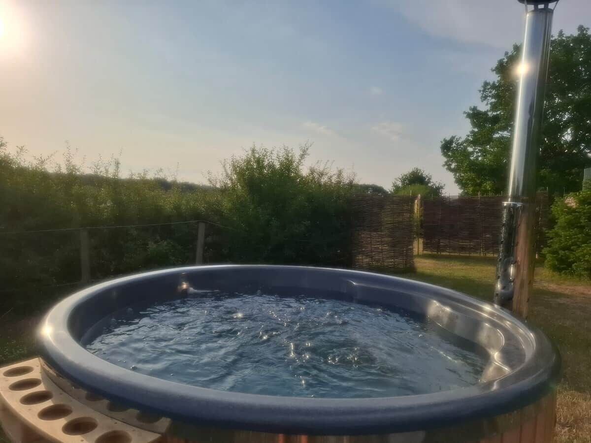 Et spabad i et udendørs miljø under en klar himmel.