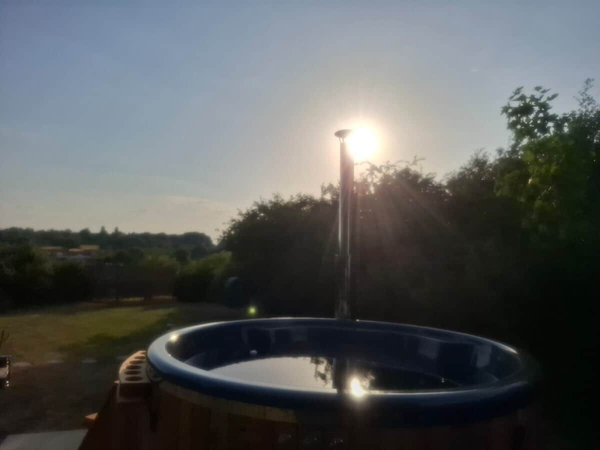A hot tub in an outdoor setting with a clear sky and sunlight.