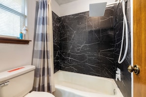 Ein Badezimmer mit Toilette, Badewanne und Dusche.