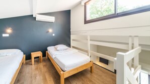 Un dormitorio con dos camas, una ventana y un banco empotrado.
