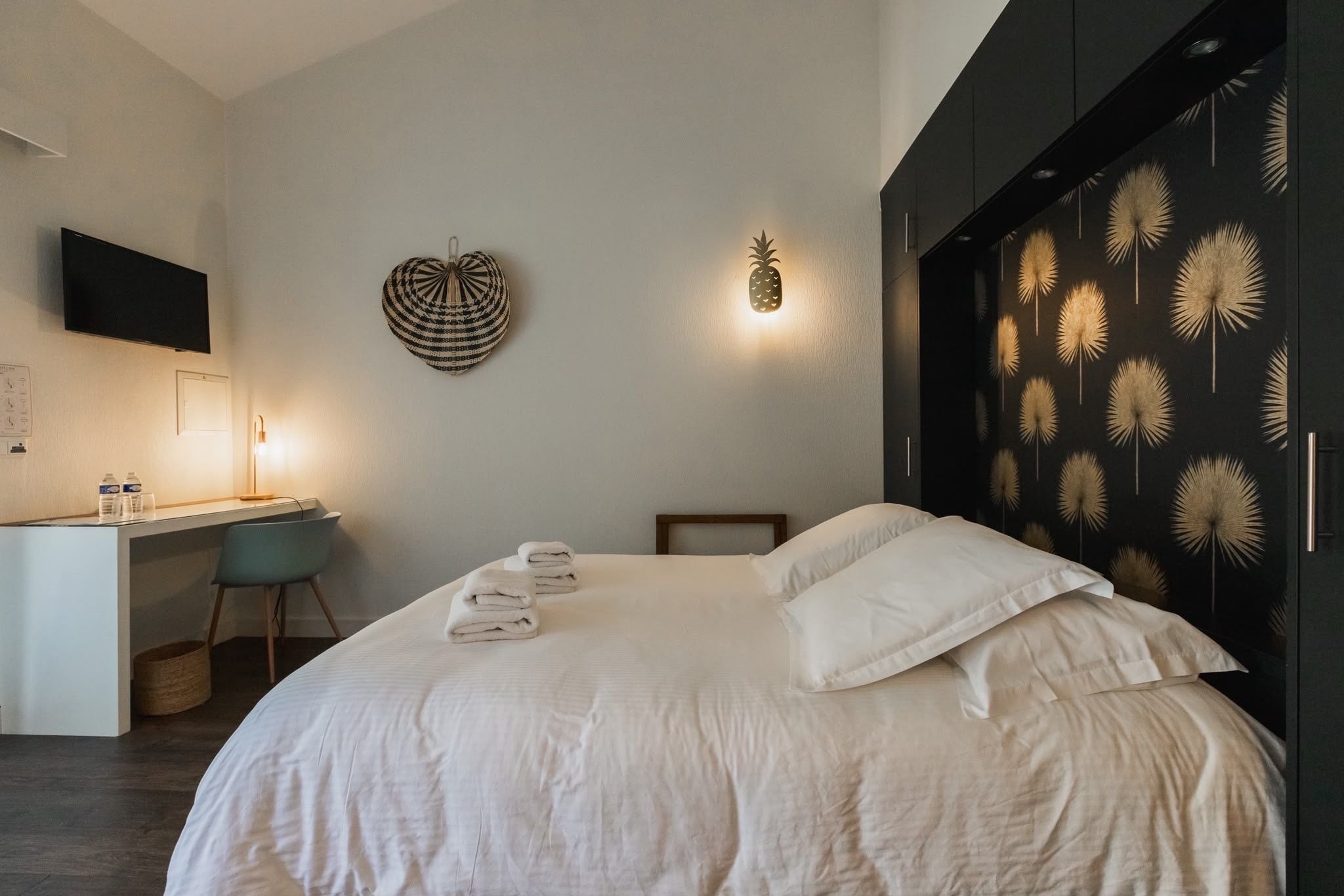 Una habitación de hotel con cama, escritorio y armario.