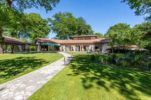 A modern house with a stone pathway leading to a covered patio area. - L'Homillon-Maison d'Hôtes (Saubion)