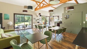 Un interior moderno con comedor, cocina y un amplio ventanal corredera que da a un espacio exterior.