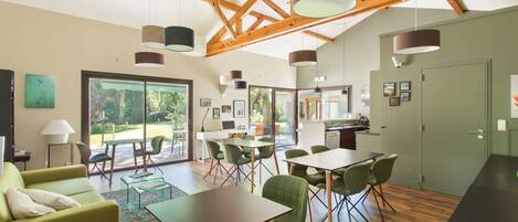 A modern interior with a dining area, kitchen, and a large sliding glass door leading to an outdoor space.