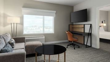 Une chambre d’hôtel équipée d’un canapé, d’un bureau, d’une chaise, d’une télévision et d’un lit.