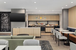 Una cocina moderna con armarios de madera, una isla central e iluminación colgante.