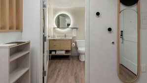 Un baño moderno con tocador, inodoro y espejo.